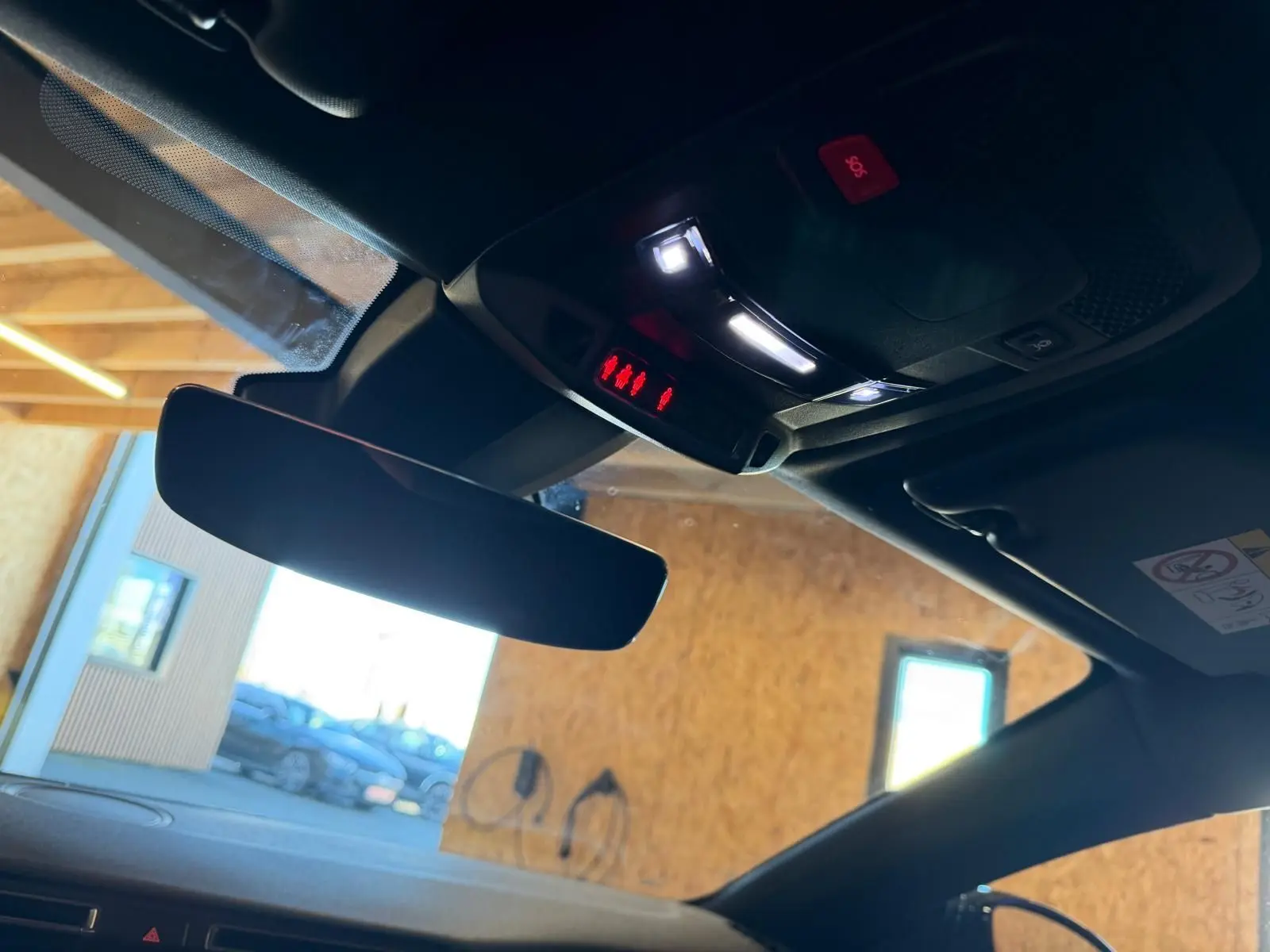 Vue intérieure du rétroviseur central et plafonnier avec éclairage LED dans un Peugeot 508 SW noir 2024.