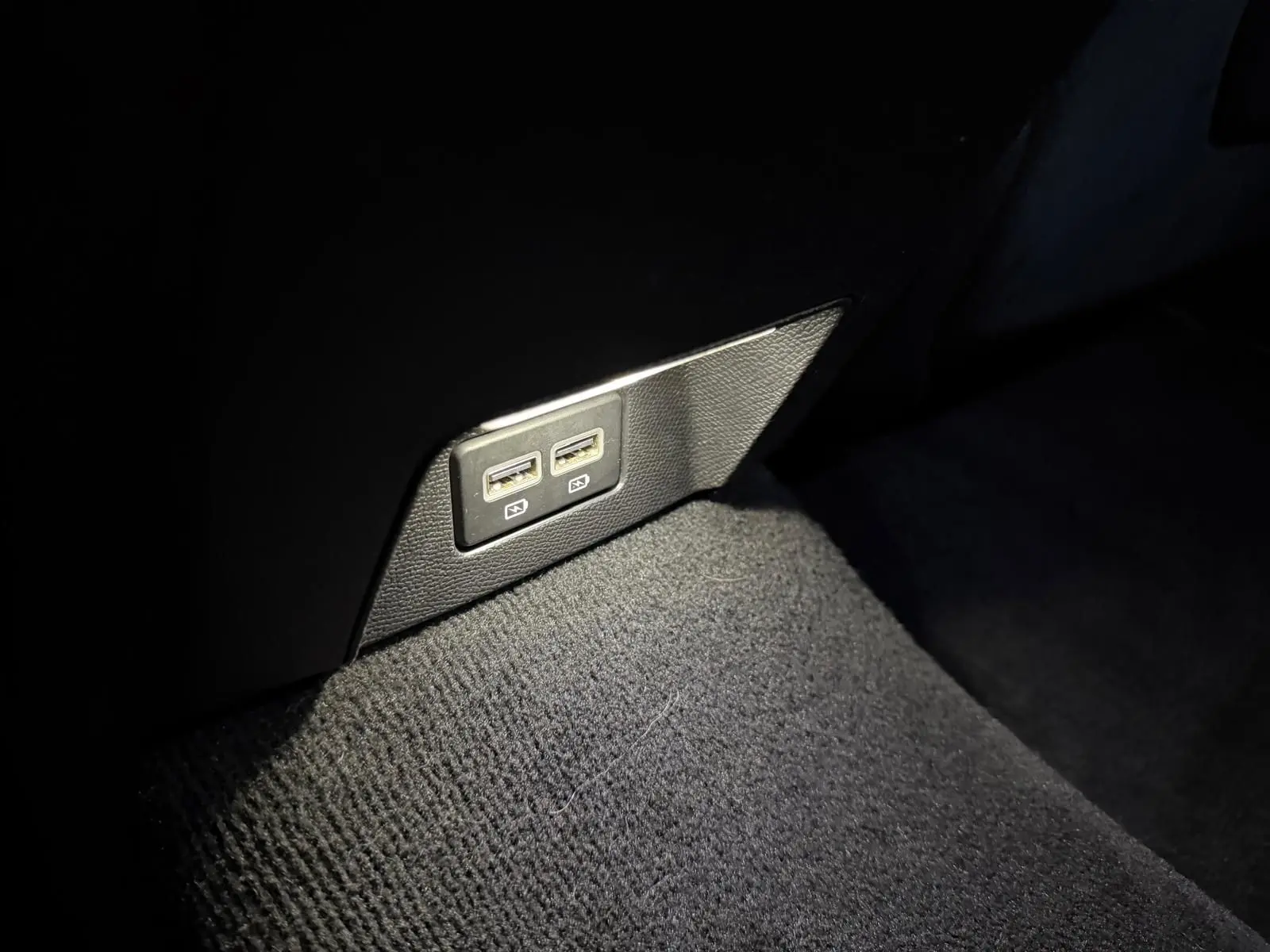 Prise USB double arrière sur tapis noir dans l’habitacle d’une Peugeot 508 SW 2024 finition GT.