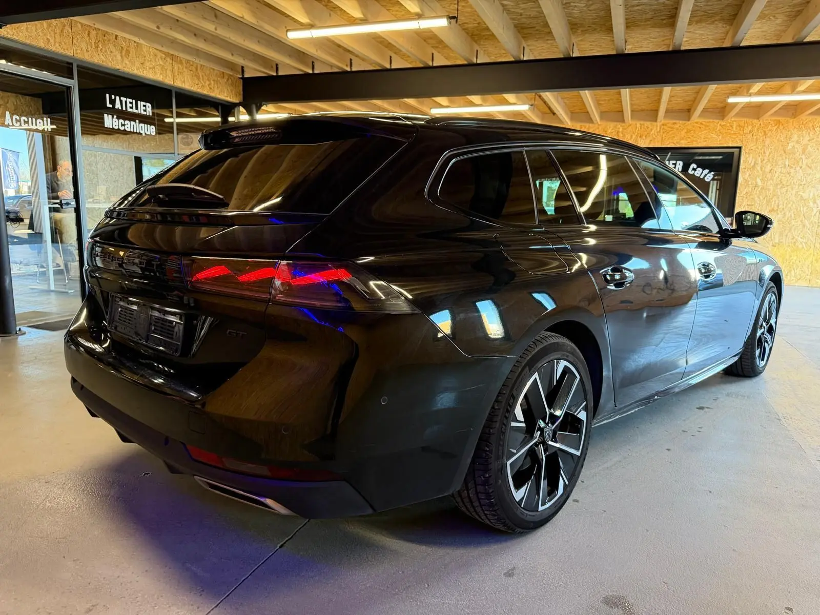 Peugeot 508 SW noire vue 3/4 arrière droit, avec feux arrière LED et jantes alliage bi-ton 18 pouces.