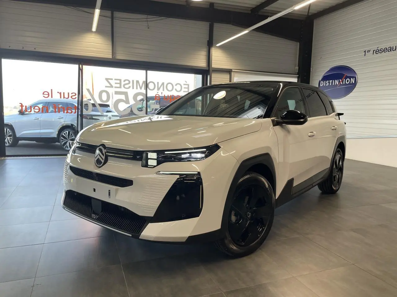 Citroën C5 Aircross blanc Okenite vue 3/4 avant en intérieur, toit noir et jantes noires brillantes.