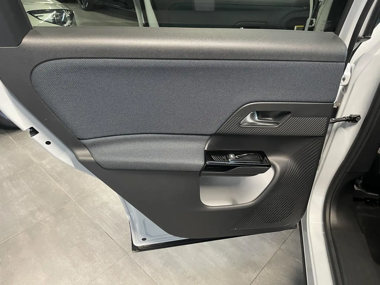 Vue rapprochée de la porte arrière droite blanche du Citroën C5 Aircross 2026 avec garniture noire texturée.