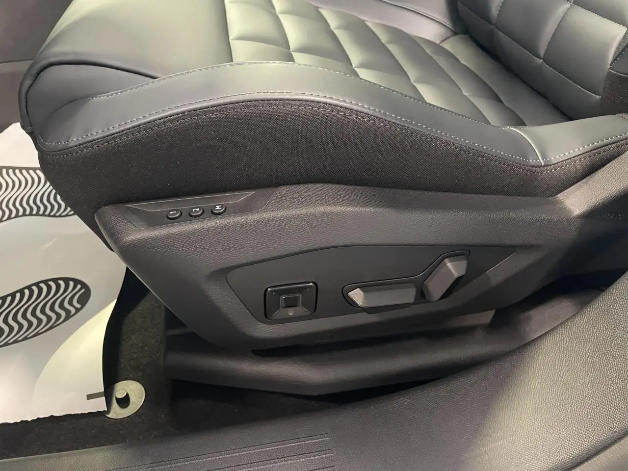 Gros plan sur les commandes de réglage électrique du siège avant en cuir noir matelassé du Citroën C5 Aircross.