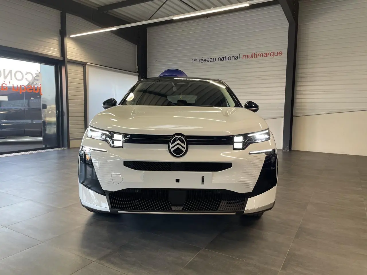 Vue avant d'un Citroën C5 Aircross blanc Okenite avec toit noir, calandre noire et feux LED distinctifs.