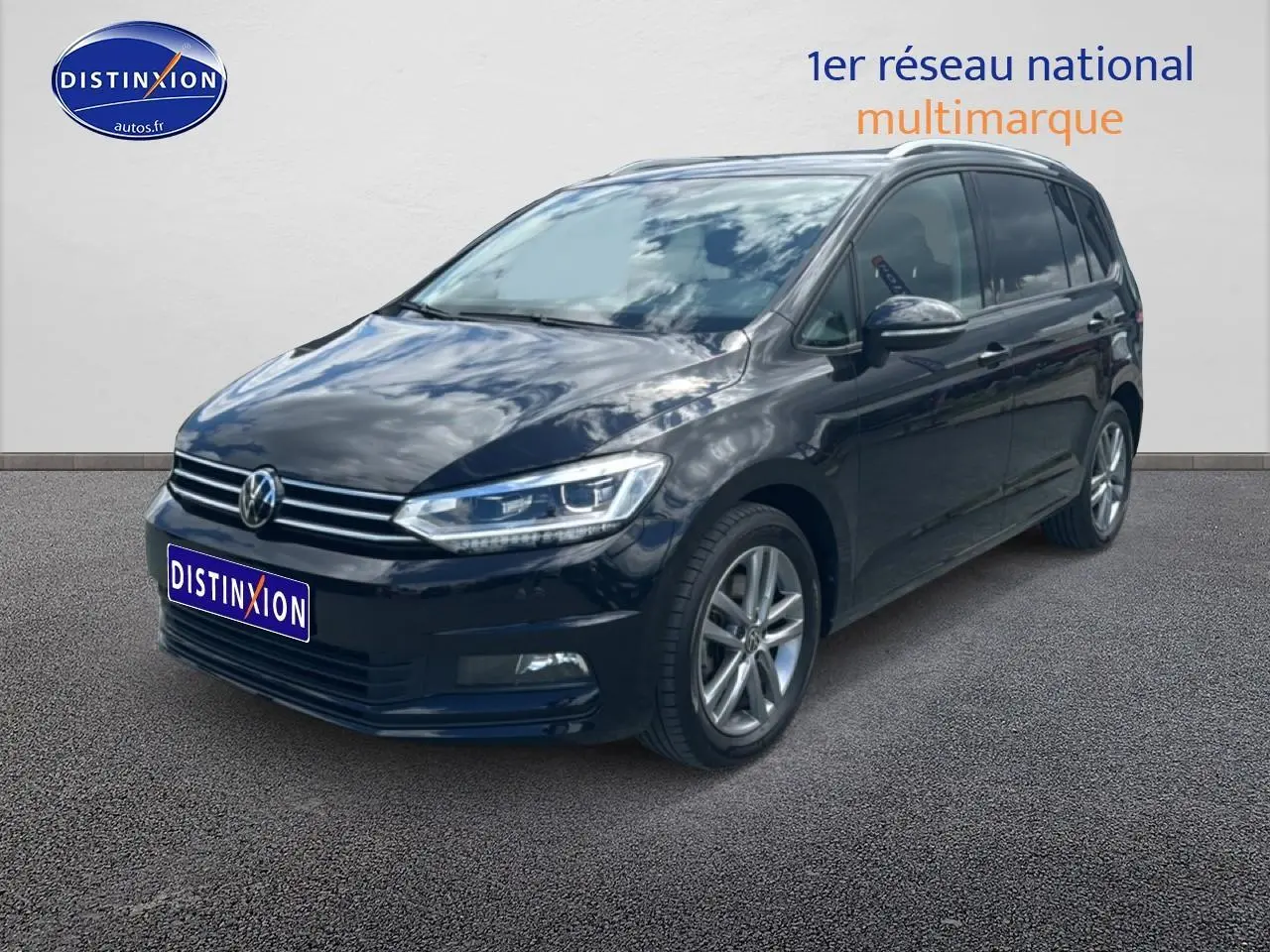 Volkswagen Touran noir 2025 en 3/4 avant droit, avec calandre chromée et jantes alu visibles.