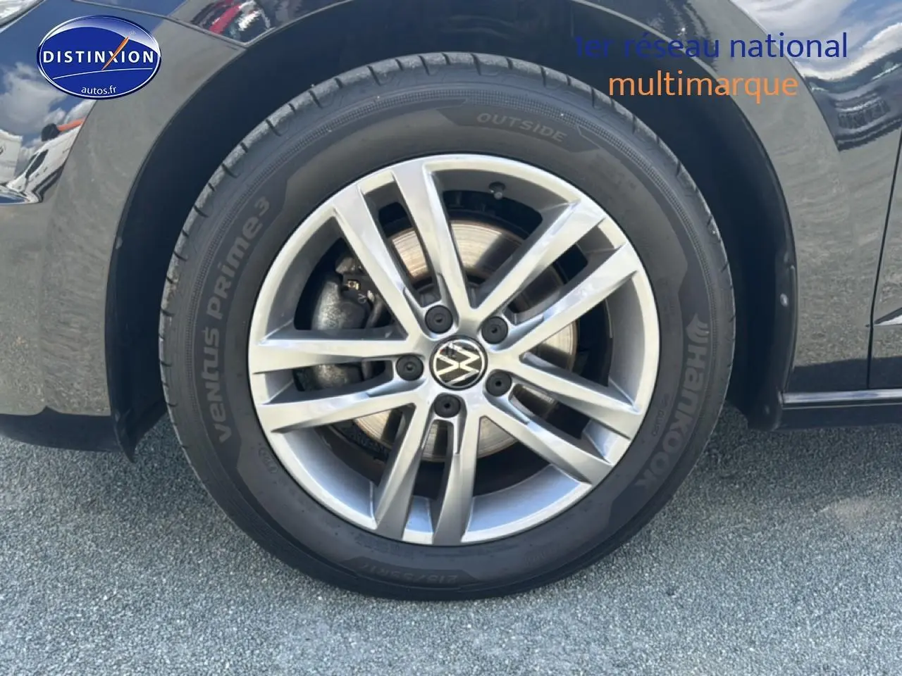 Gros plan sur la roue avant droite alu argentée d’un Volkswagen Touran noir 2025 avec pneu Hankook.