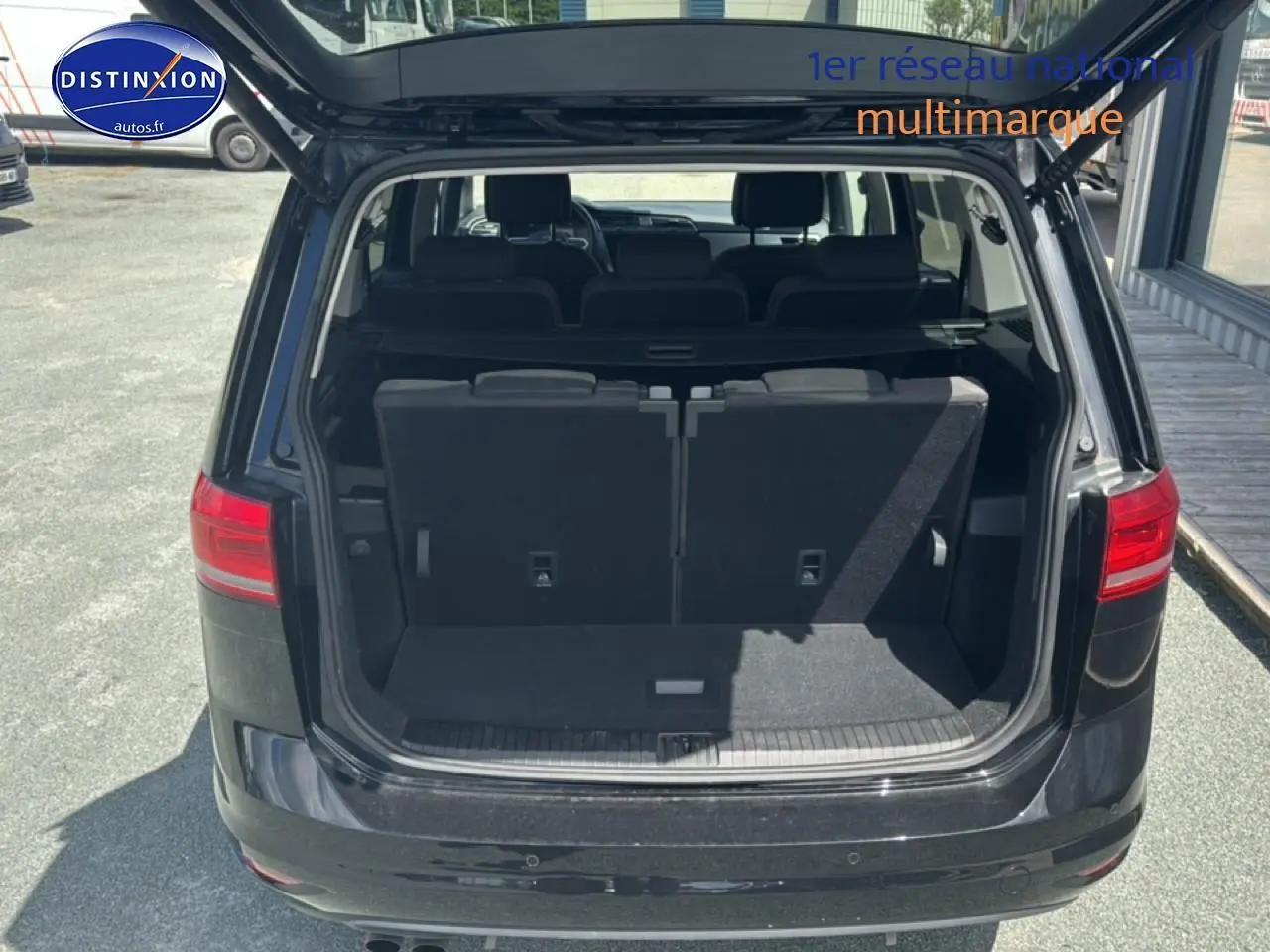 Vue arrière du Volkswagen Touran noir 2025 avec coffre ouvert et troisième rangée de sièges visibles.