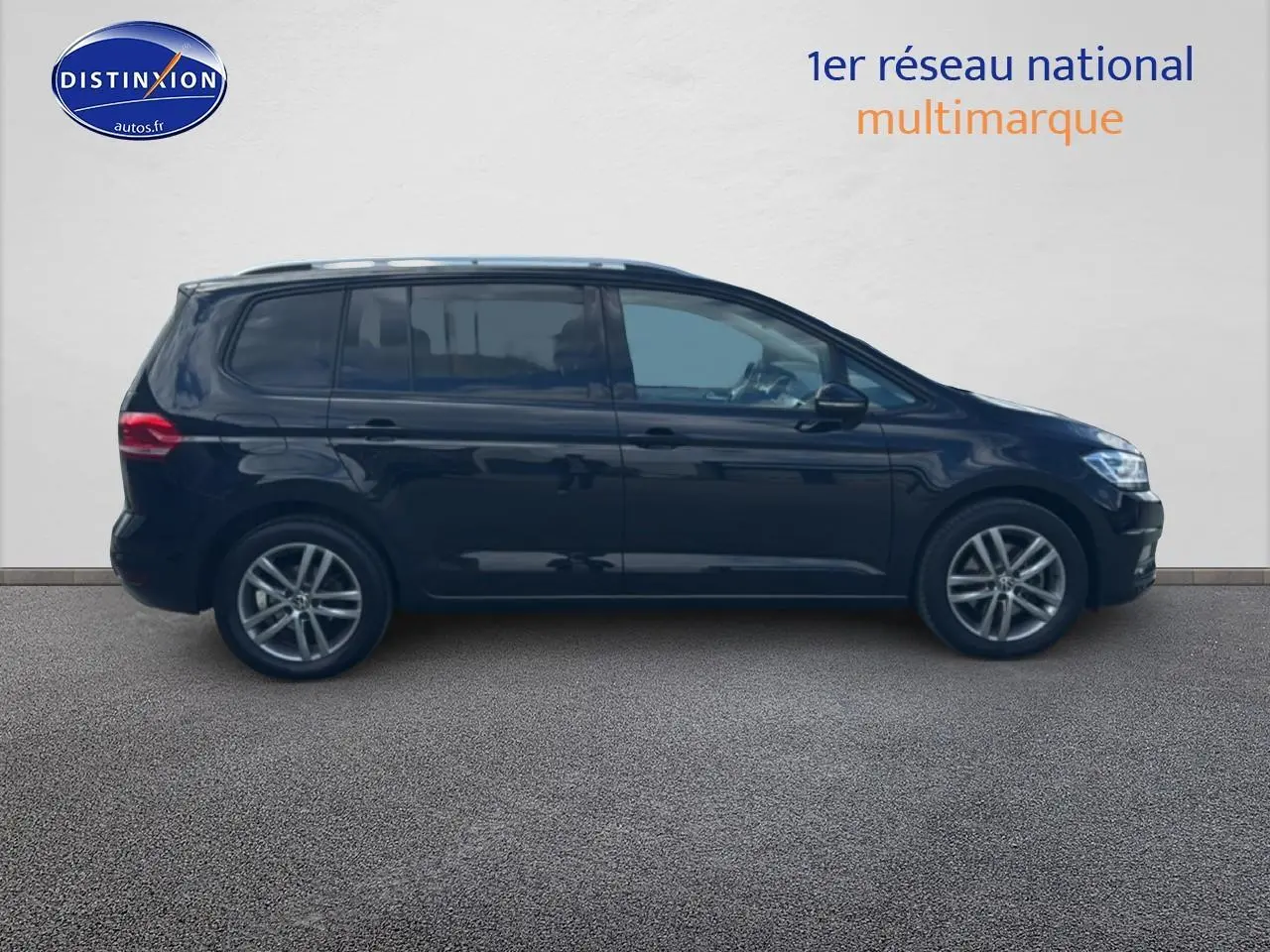 Profil côté gauche d'un Volkswagen Touran noir 2025 avec barres de toit et jantes alliage.