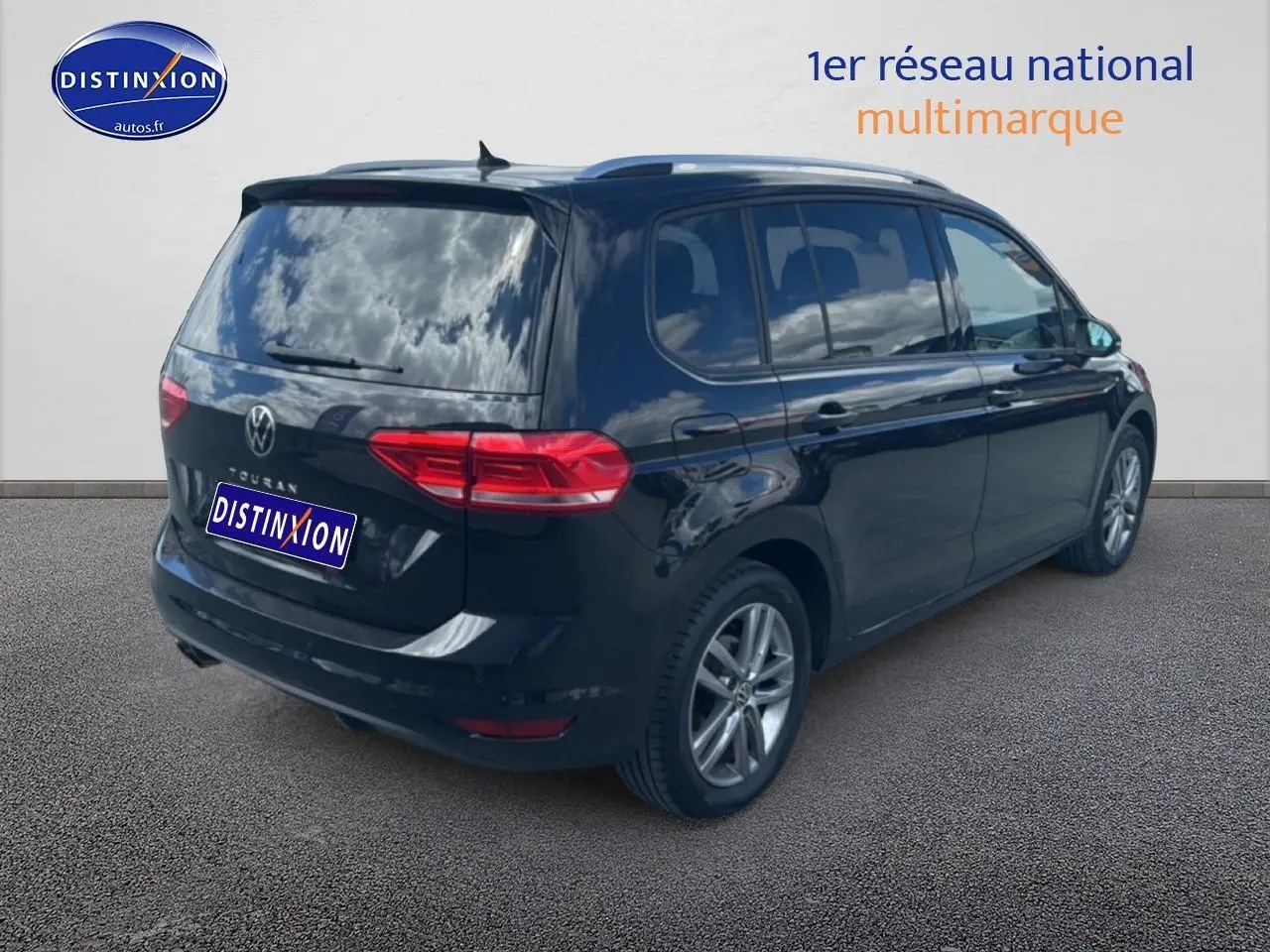 Vue 3/4 arrière droite d'un Volkswagen Touran noir 2025 avec vitres surteintées et jantes alu.