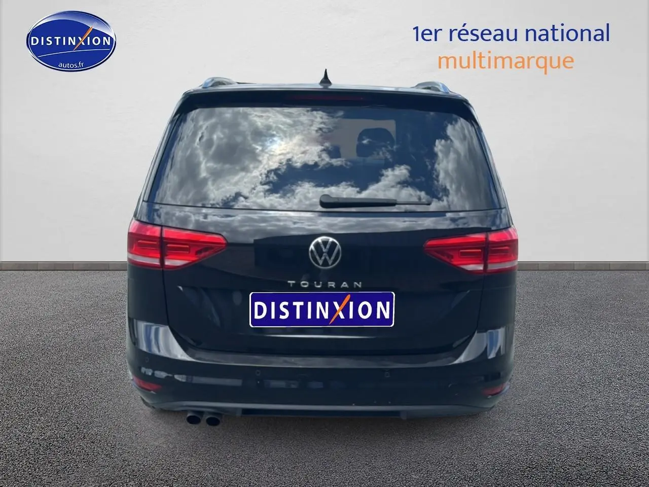 Vue arrière d'un Volkswagen Touran noir 2025 avec feux rouges et double sortie d'échappement visible.