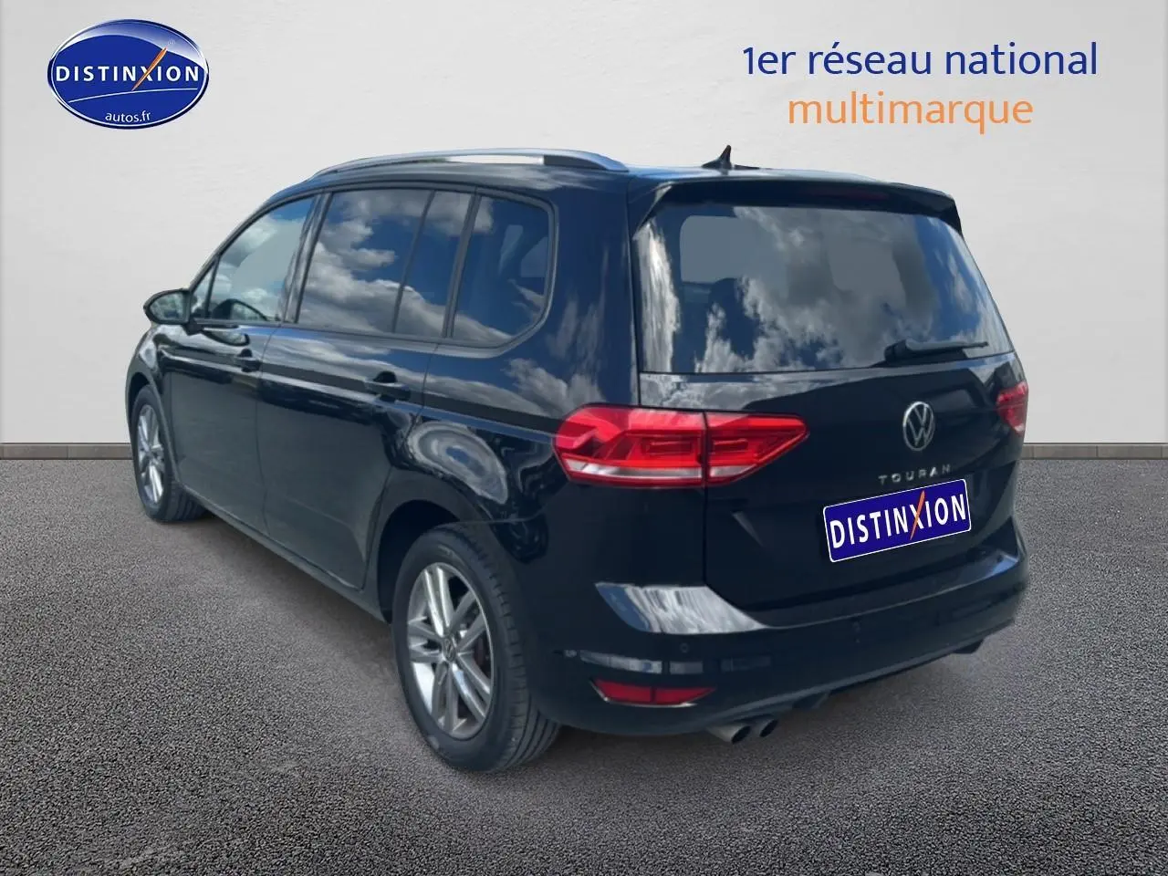 Volkswagen Touran noir vu en 3/4 arrière droit, avec vitres surteintées et jantes alu visibles.