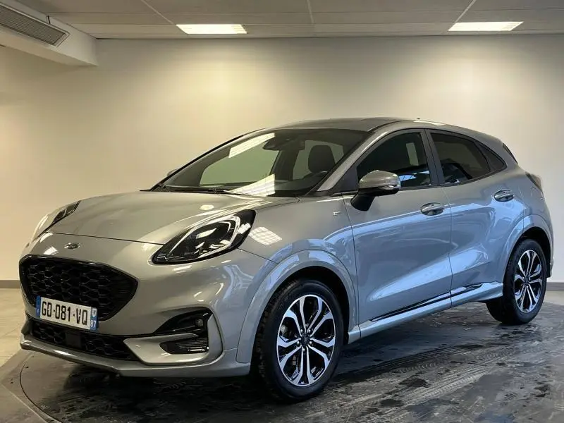 Ford Puma gris Solar métallisé en vue 3/4 avant droit avec jantes alu et toit noir contrasté dans un intérieur neutre.