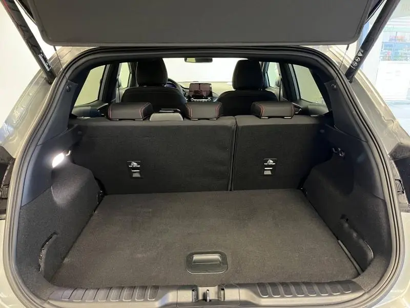 Coffre ouvert vu de l'arrière d'un Ford Puma gris Solar Métallisée avec banquette arrière noire et appuie-têtes rouges.