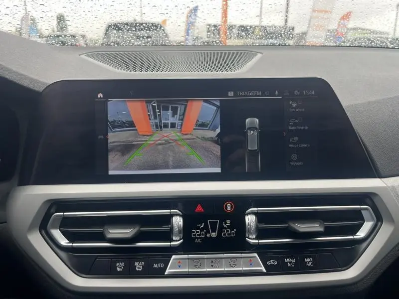 Vue intérieure du tableau de bord de la BMW Série 3 316dA 2021 avec écran de caméra de recul et commandes climatisation.