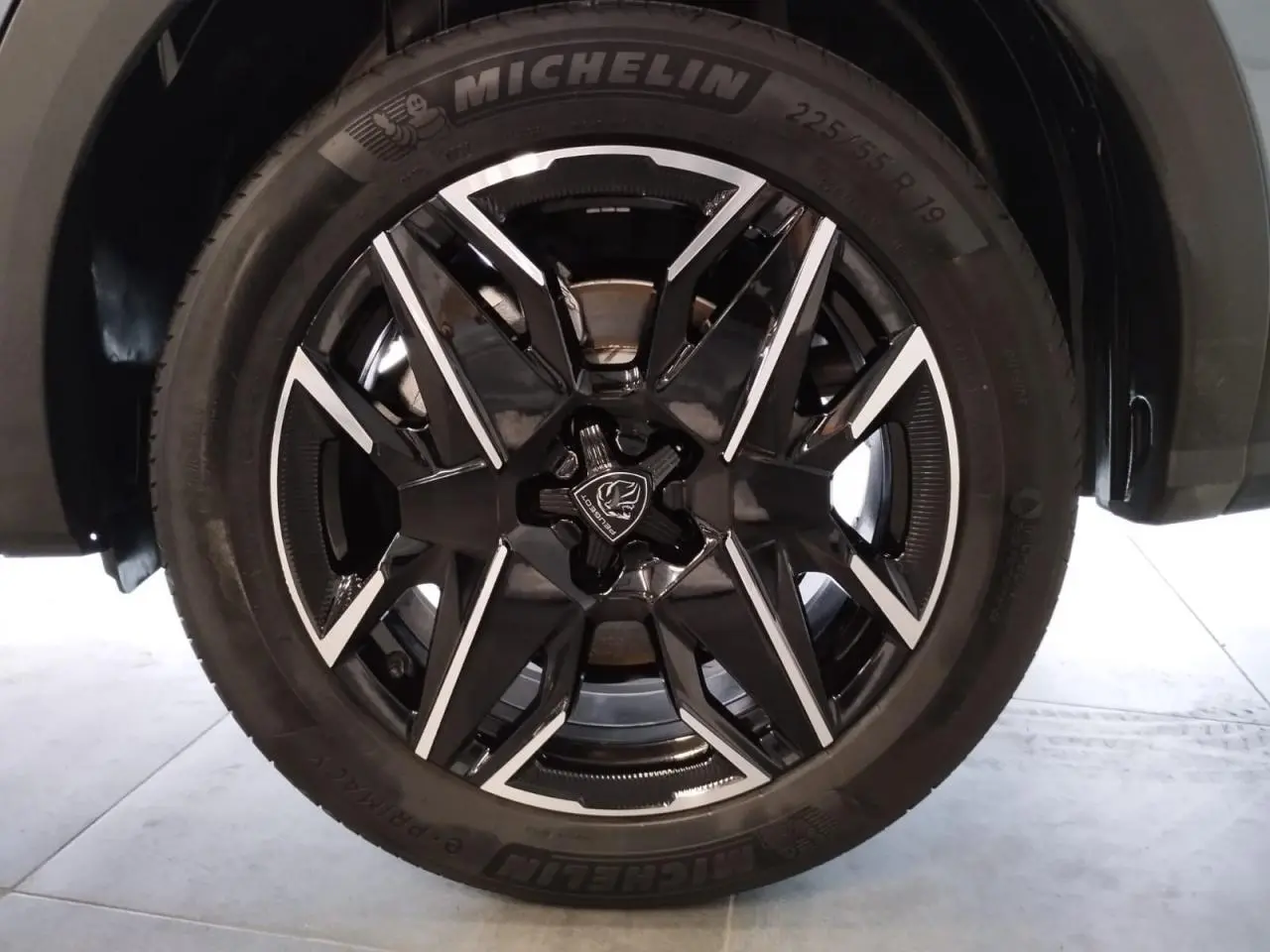 Gros plan sur la jante alliage 19'' noire et diamantée du Peugeot 5008 Bleu Ingaro, avec pneu Michelin visible.