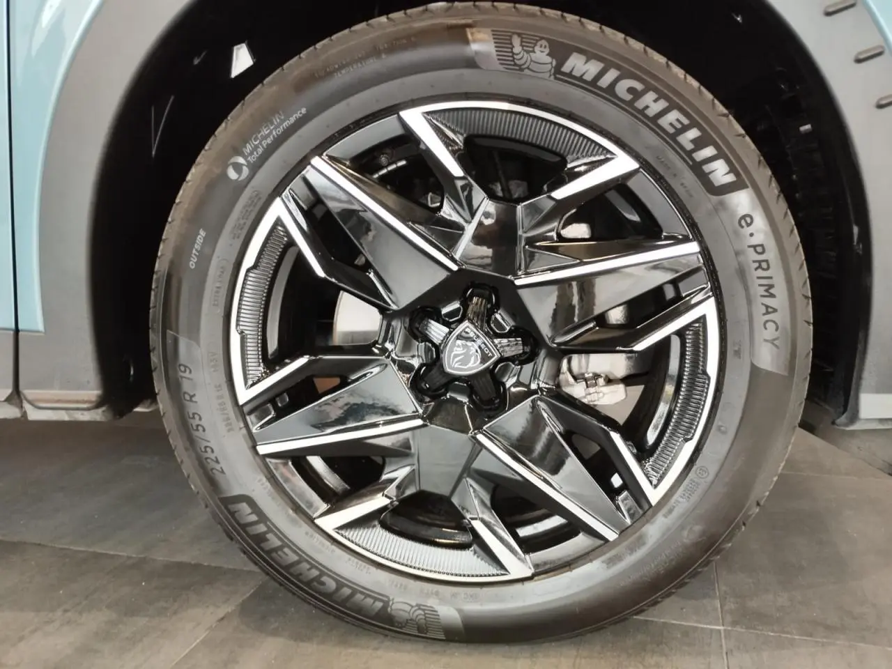 Gros plan sur la jante alliage 19'' noire diamantée du PEUGEOT 5008 Bleu Ingaro, avec logo lion au centre.