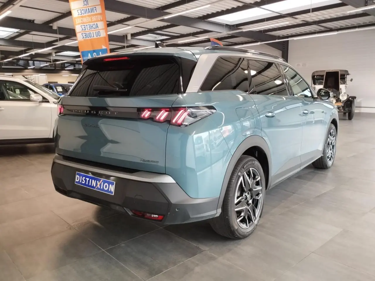 Vue 3/4 arrière droite d’un Peugeot 5008 bleu Ingaro avec feux arrière à LED 3 griffes et jantes alliage 19 pouces.