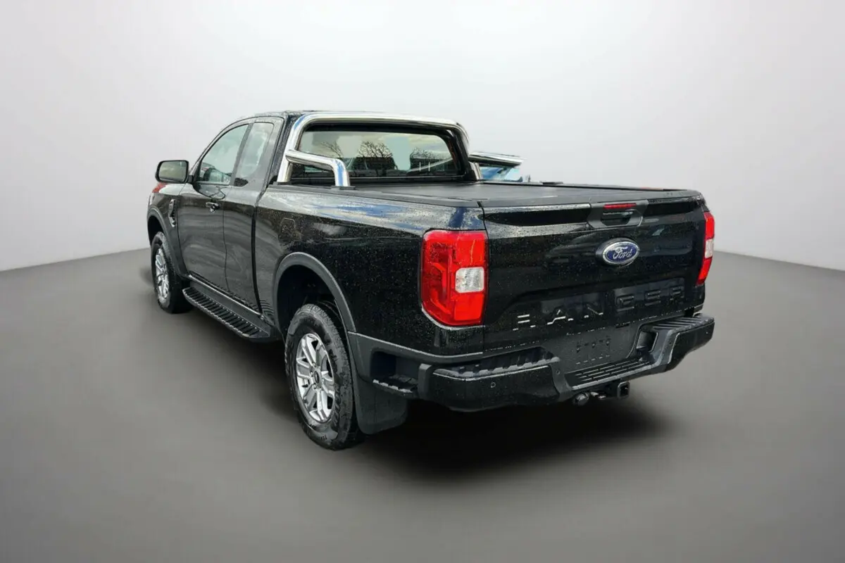 Ford Ranger TDCI 170 noir shadow en 3/4 arrière droit, avec rideau coulissant et arceaux inox visibles sur la benne.