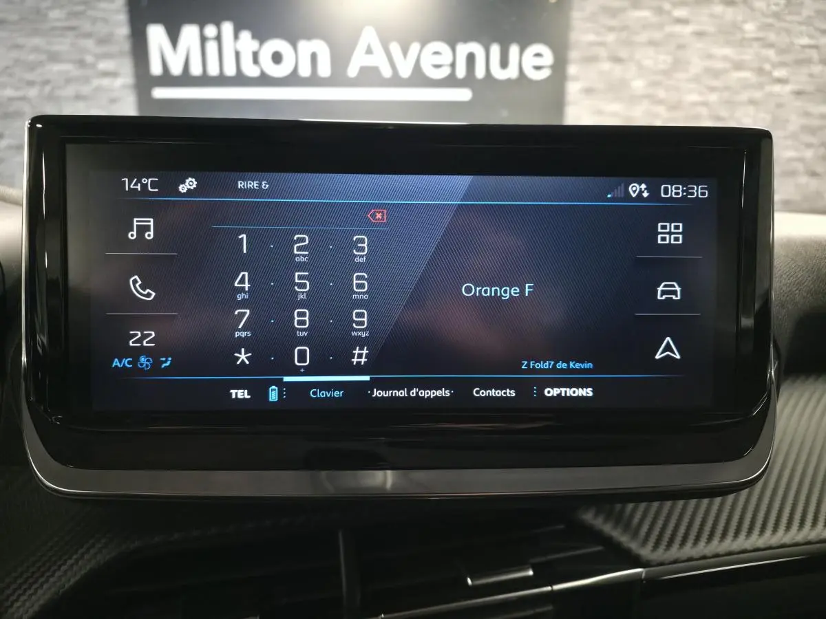 Écran tactile central du Peugeot 2008 2025 affichant le clavier téléphonique, avec décor carbone autour.