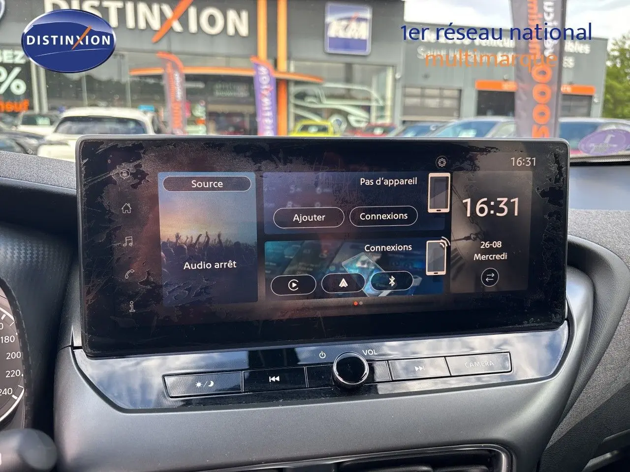 Vue rapprochée de l’écran tactile central du Nissan Juke Hybrid 2024 gris squale metal avec interface multimédia affichée.