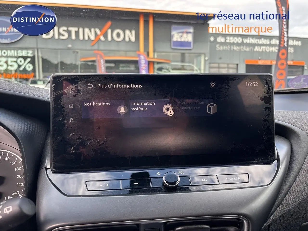 Écran tactile central du Nissan Juke Hybrid 2024 en intérieur, avec commandes audio et caméra visibles.