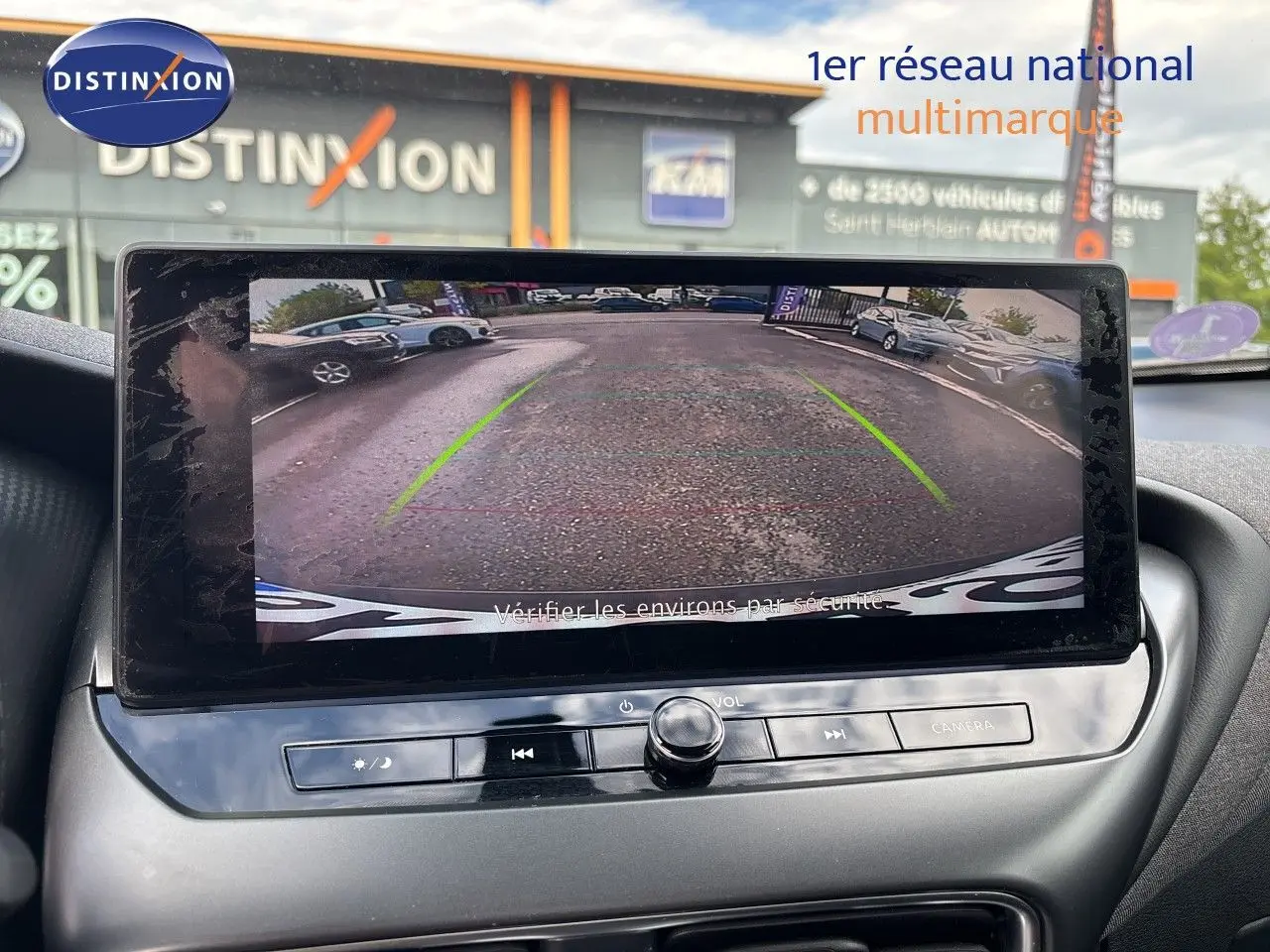 Écran central montrant la caméra de recul d’un Nissan Juke Hybrid gris squale metal, vue intérieure avant.
