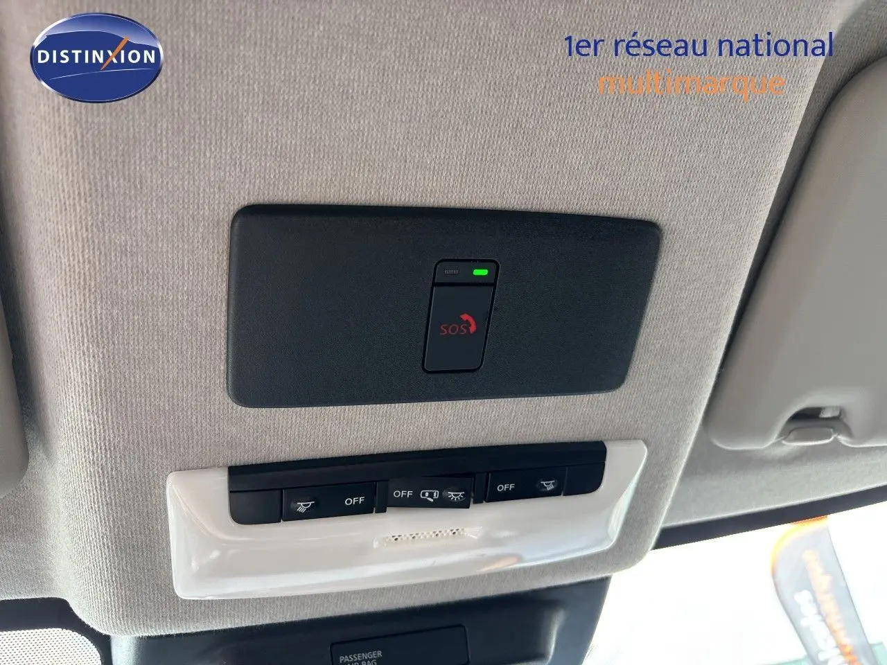 Vue intérieure du plafond avec bouton SOS et commandes d’éclairage dans un Nissan Juke Hybrid gris Squale Metal 2024.