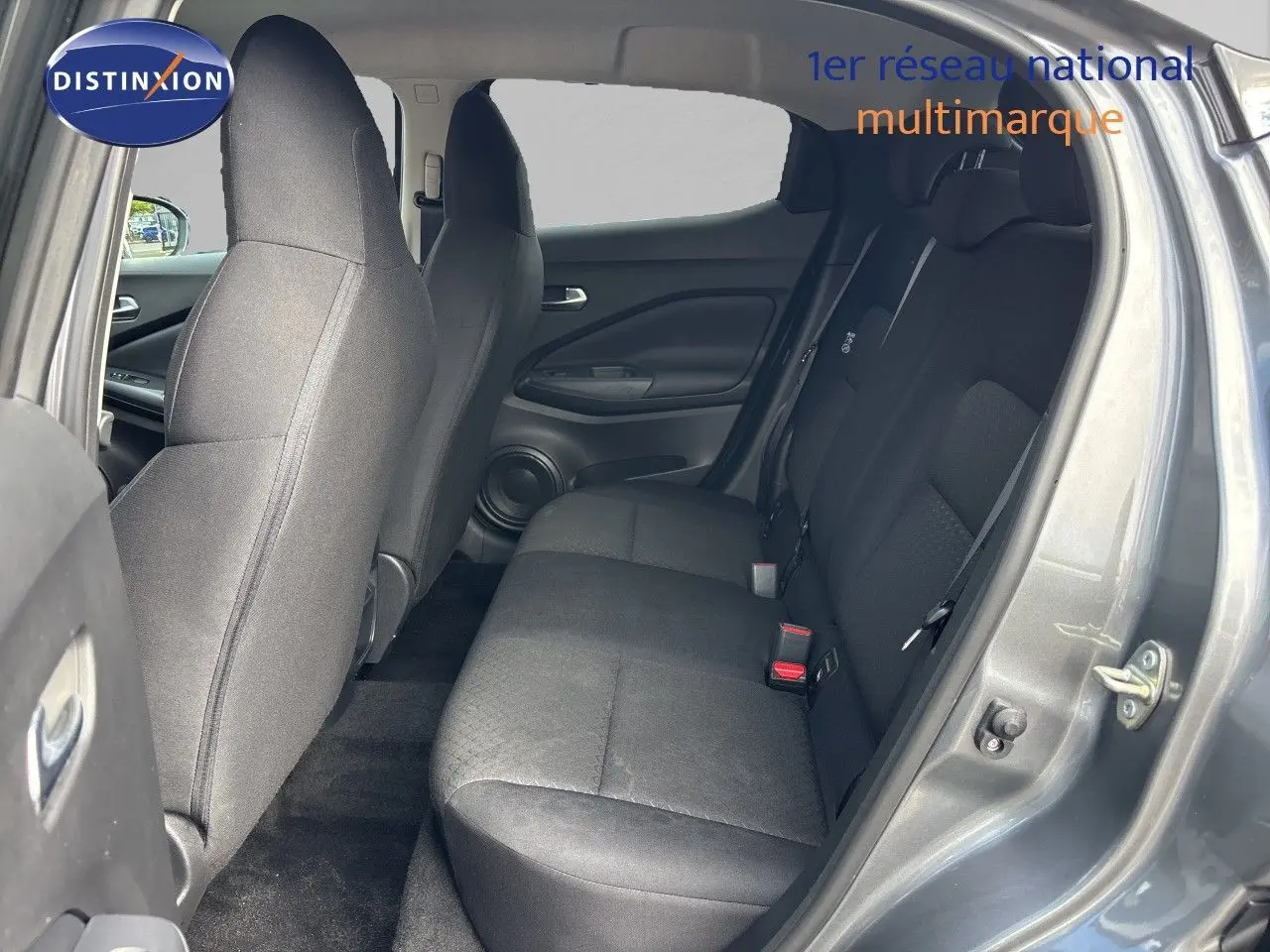 Vue intérieure côté droit des sièges arrière noirs en tissu du Nissan Juke Hybrid 2024 gris squale metal.