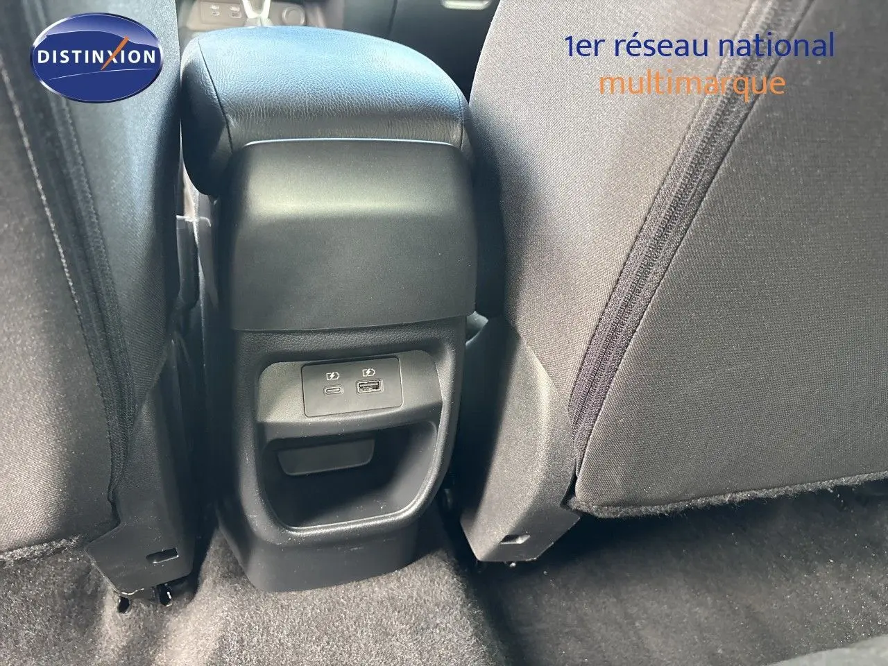 Vue rapprochée de la console arrière entre les sièges noirs en tissu du Nissan Juke gris Squale Metal 2024.