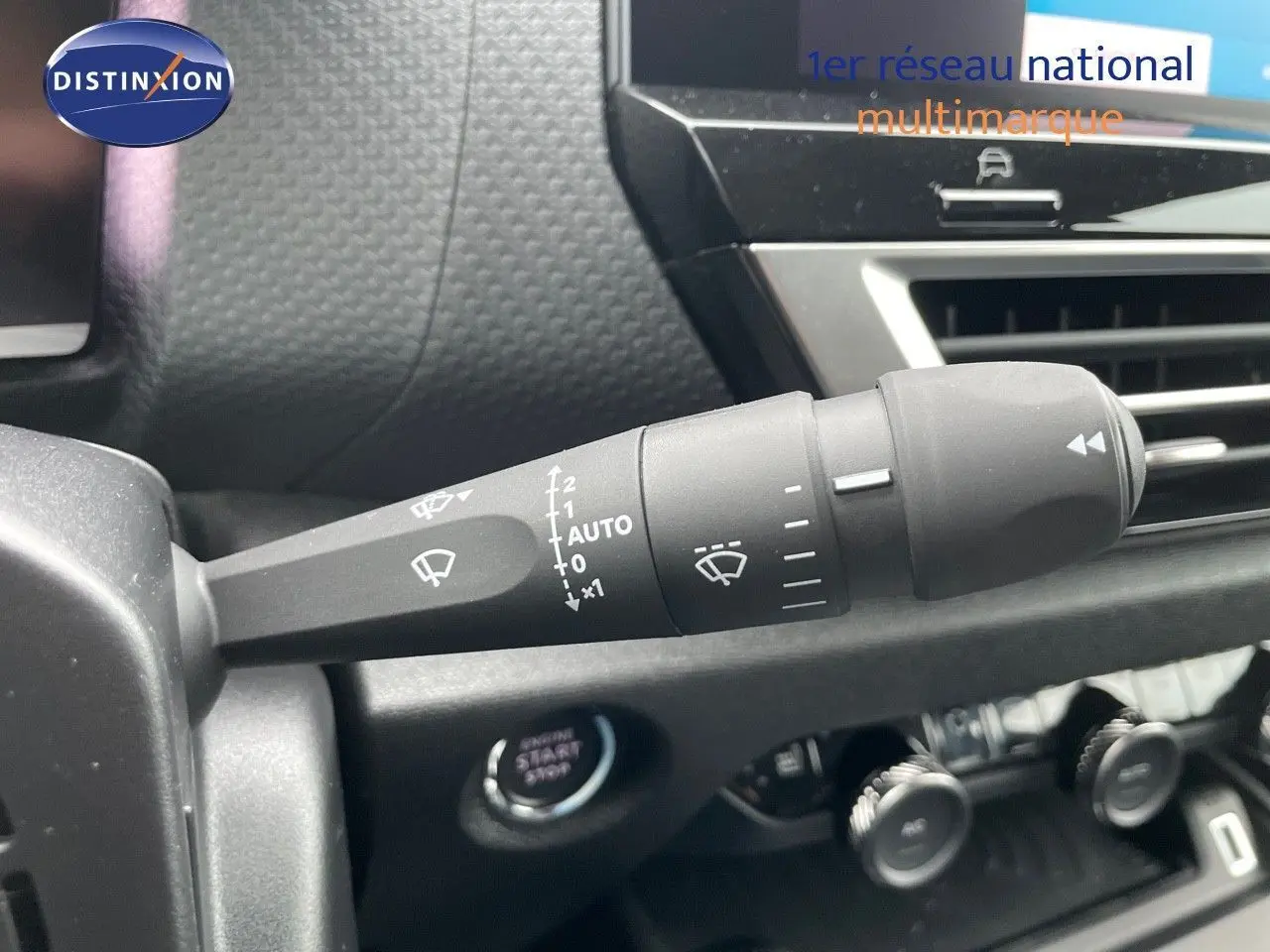 Gros plan sur la commande d'essuie-glace à gauche du tableau de bord d'une Citroën C4 blanche métal 2024.