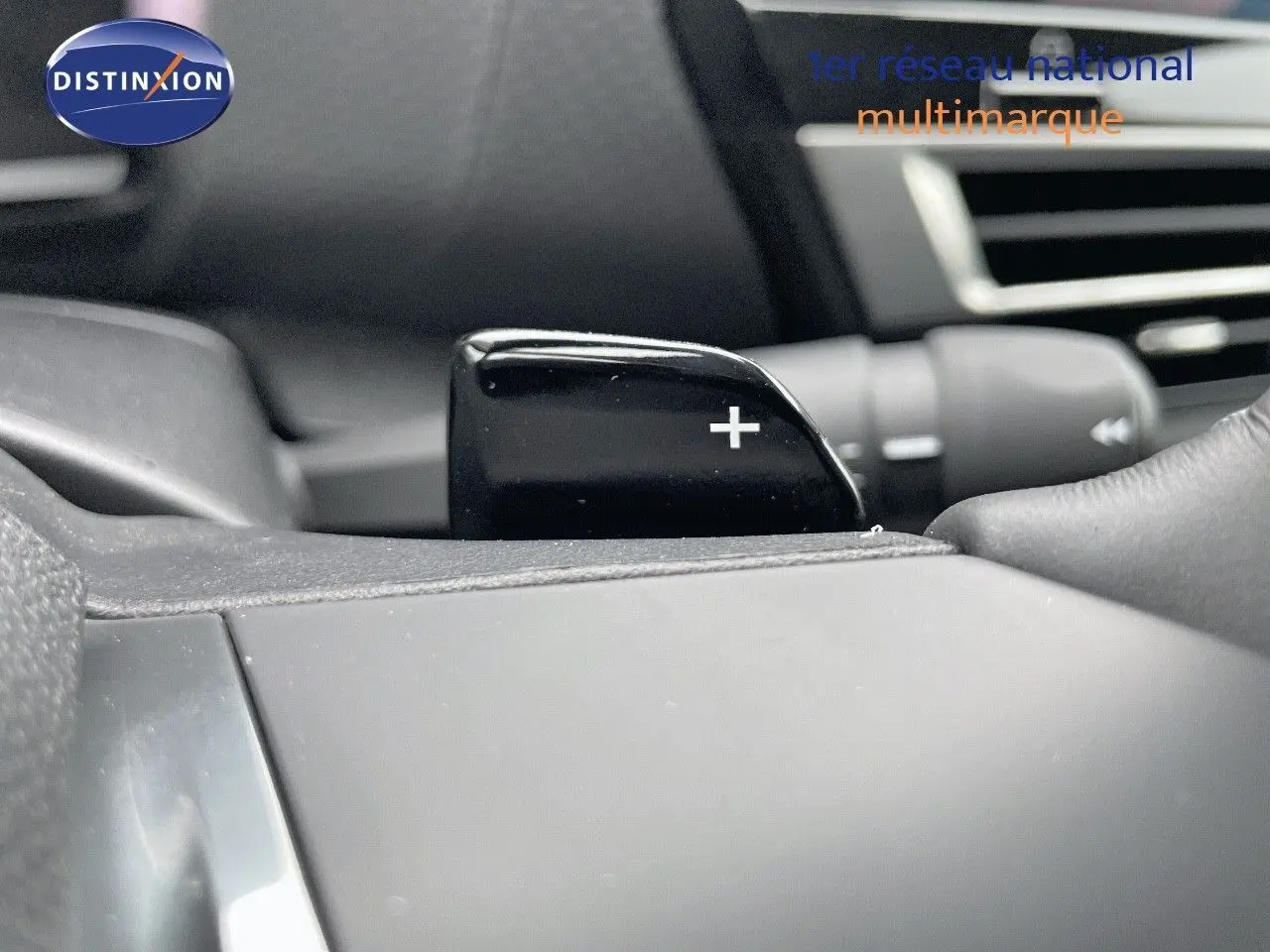 Gros plan sur la palette de passage de vitesses "+" côté droit du volant d'une Citroën C4 blanche métal 2024.