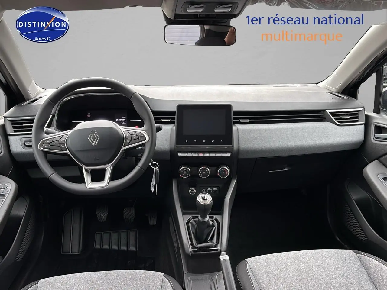 Intérieur avant de la Renault Clio V noire 2025, volant multifonction et boîte manuelle visibles, tableau de bord moderne.