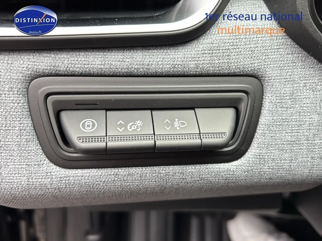 Boutons de réglage de verrouillage, luminosité et phares sur tableau de bord tissu gris d'une Renault Clio V noire vue de près