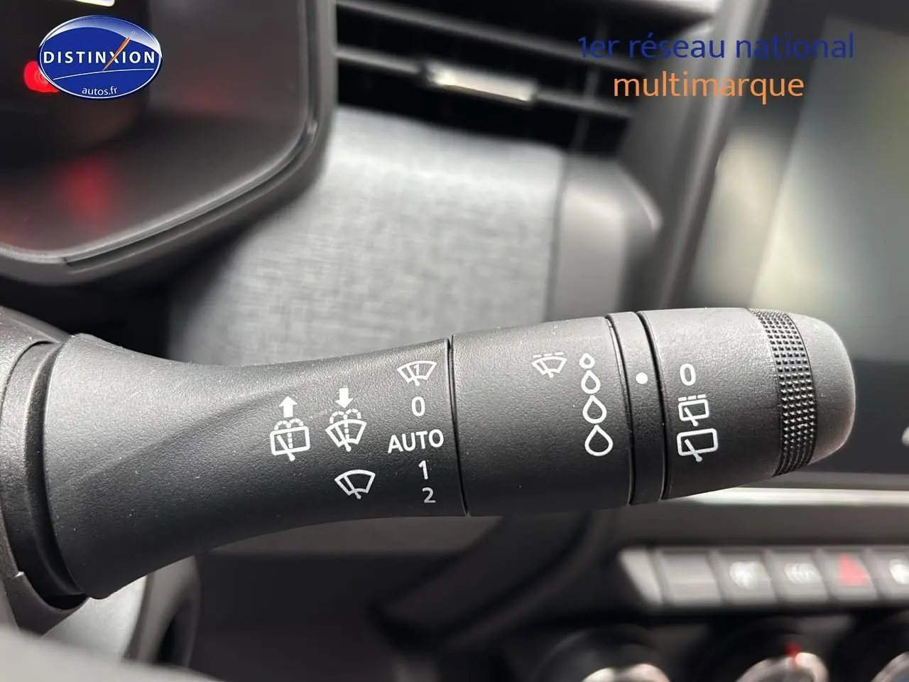 Gros plan sur la commande d'essuie-glace noire dans l'habitacle d'une Renault Clio V noire de 2025.