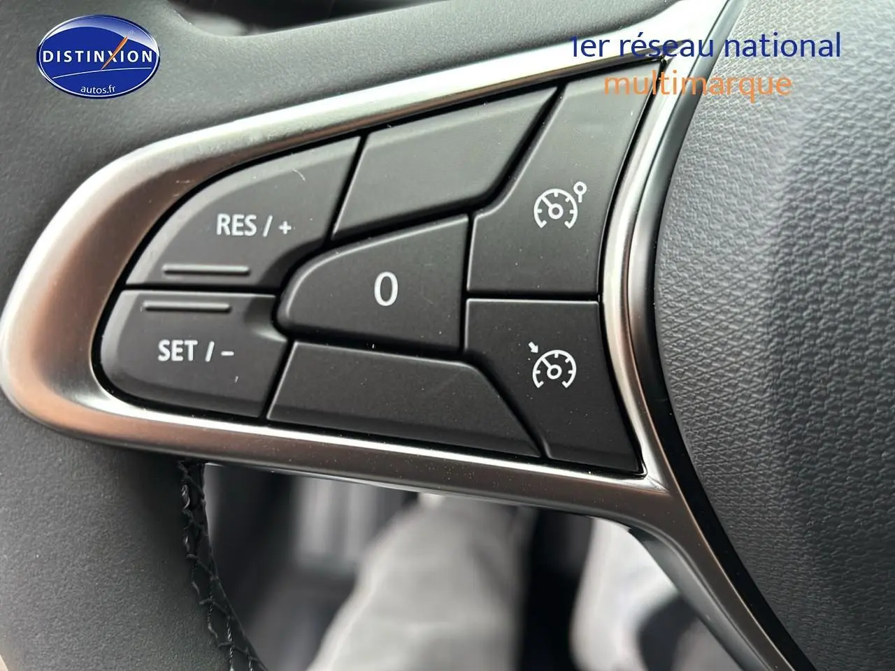 Gros plan sur les commandes du régulateur de vitesse au volant d'une Renault Clio V noire, version 1.5 blue dci 100 evolution.