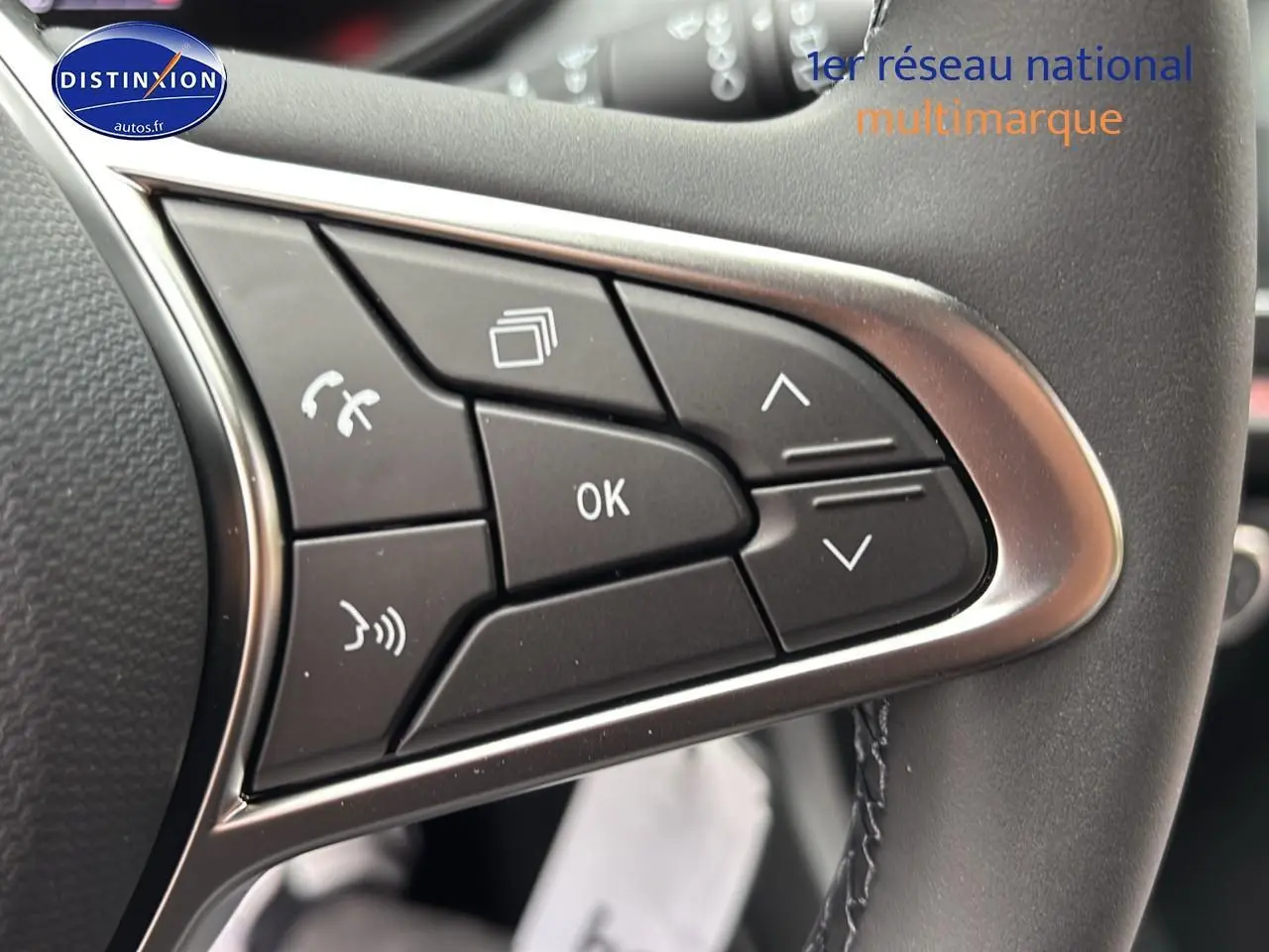 Gros plan sur les commandes multifonctions à gauche du volant d'une Renault Clio V noire, modèle 2025.