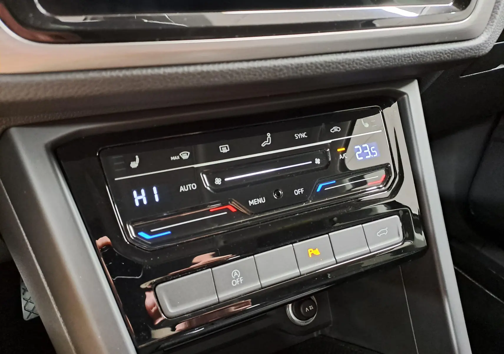 Gros plan sur la console centrale du Volkswagen Touran 2025, affichage numérique de la climatisation et boutons de commande.