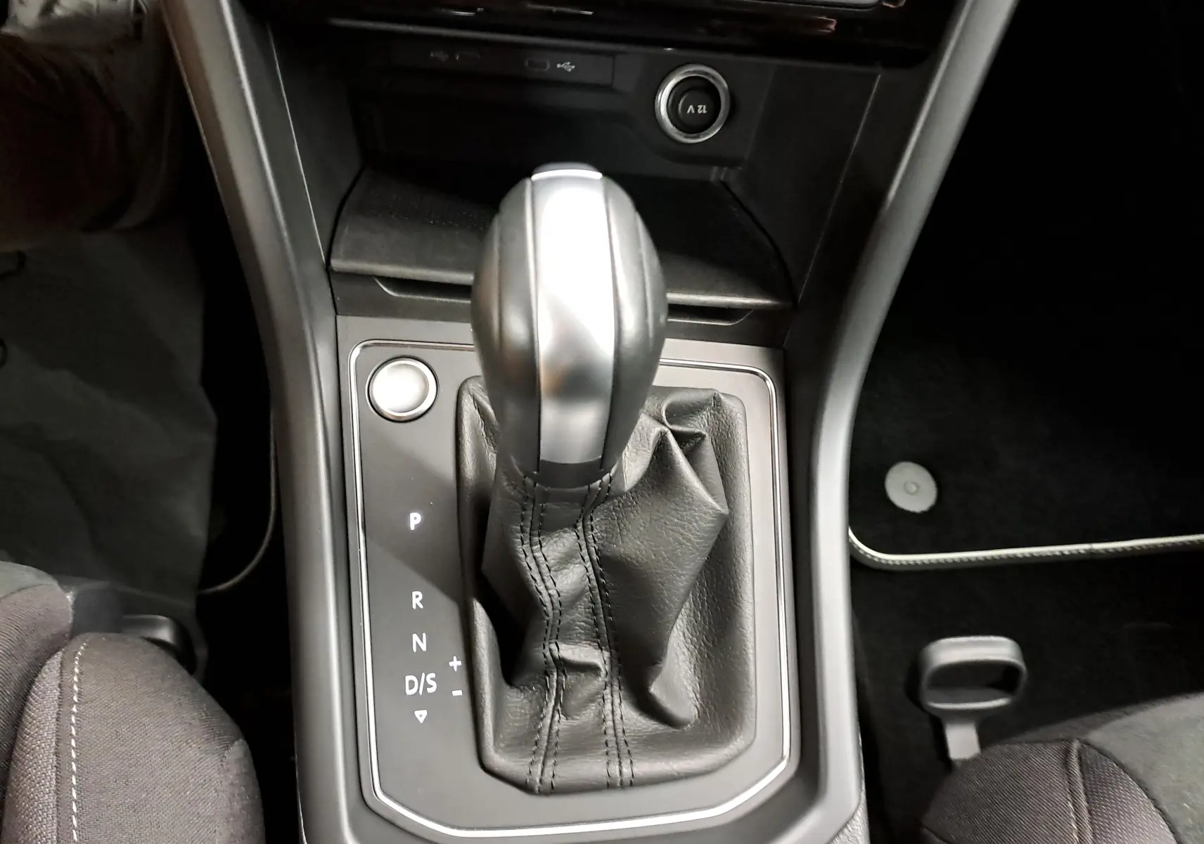Vue rapprochée du levier de vitesse automatique du Volkswagen Touran 2025, avec sellerie noire visible autour.