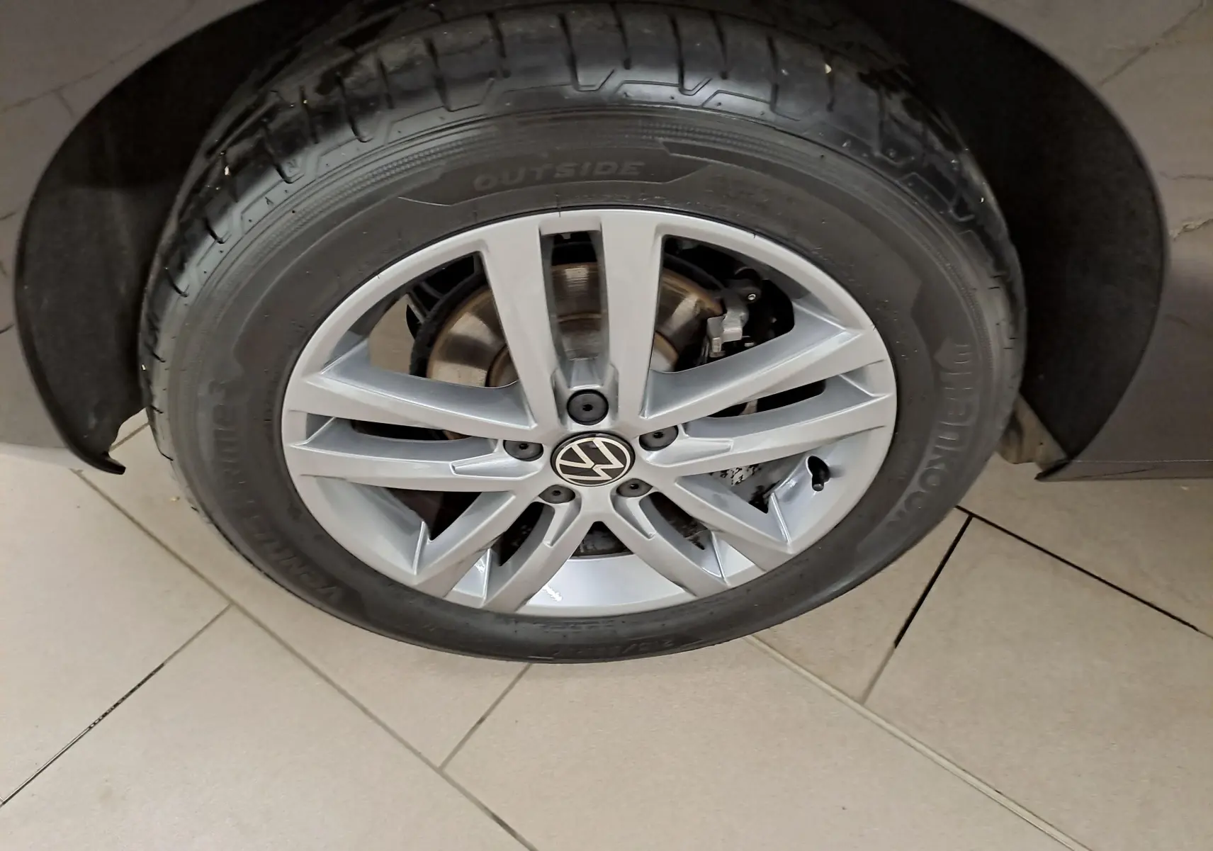 Gros plan sur la roue avant droite du Volkswagen Touran 2025 noir grenadille avec jante alliage argentée.