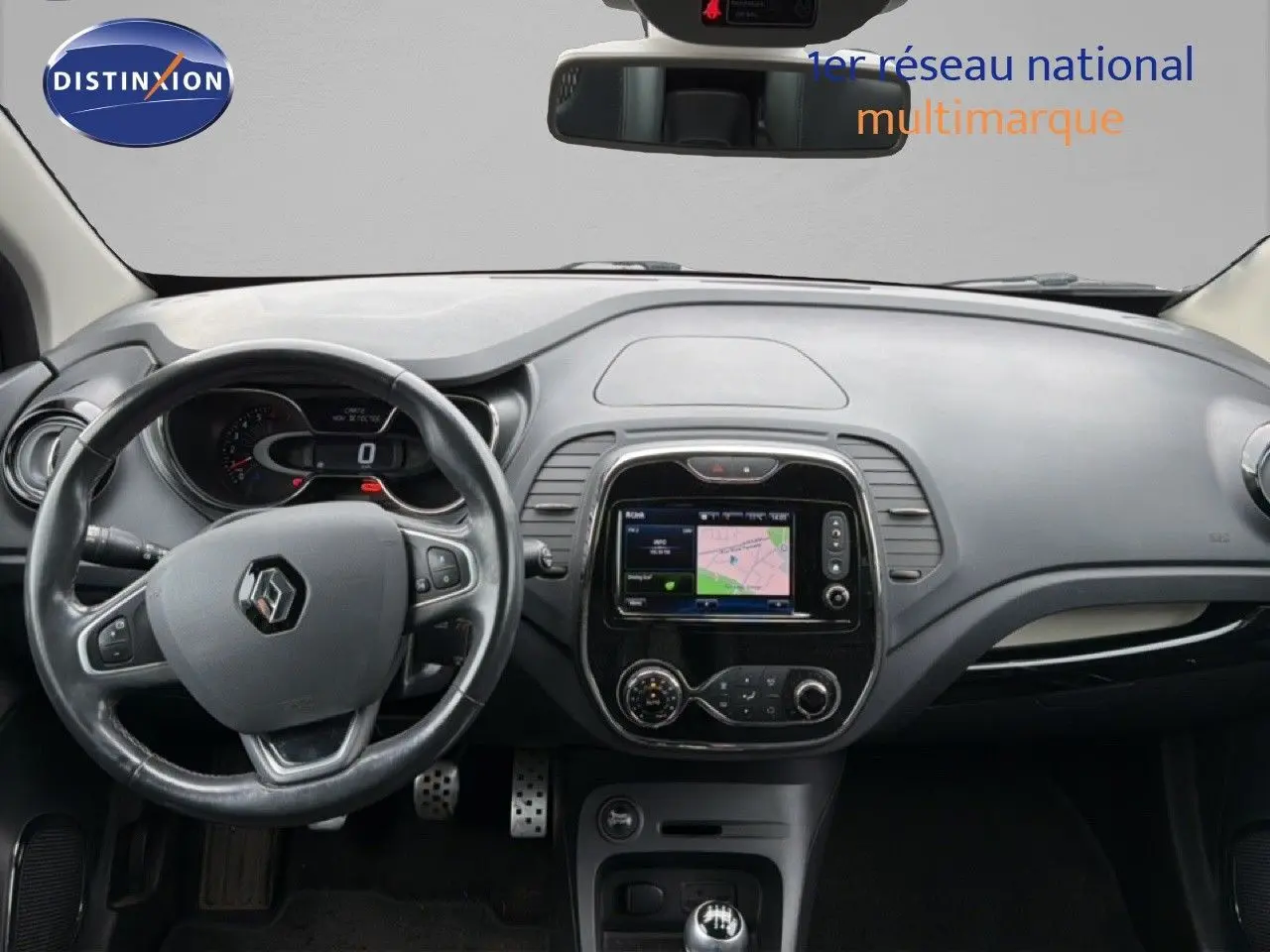 Vue intérieure frontale du tableau de bord gris et volant Renault Captur 1.2 TCE 120 Intens avec écran tactile et boîte manuelle.