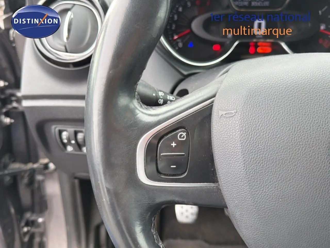 Gros plan sur le volant en cuir noir du Renault Captur 2016, avec commandes de régulateur de vitesse visibles.