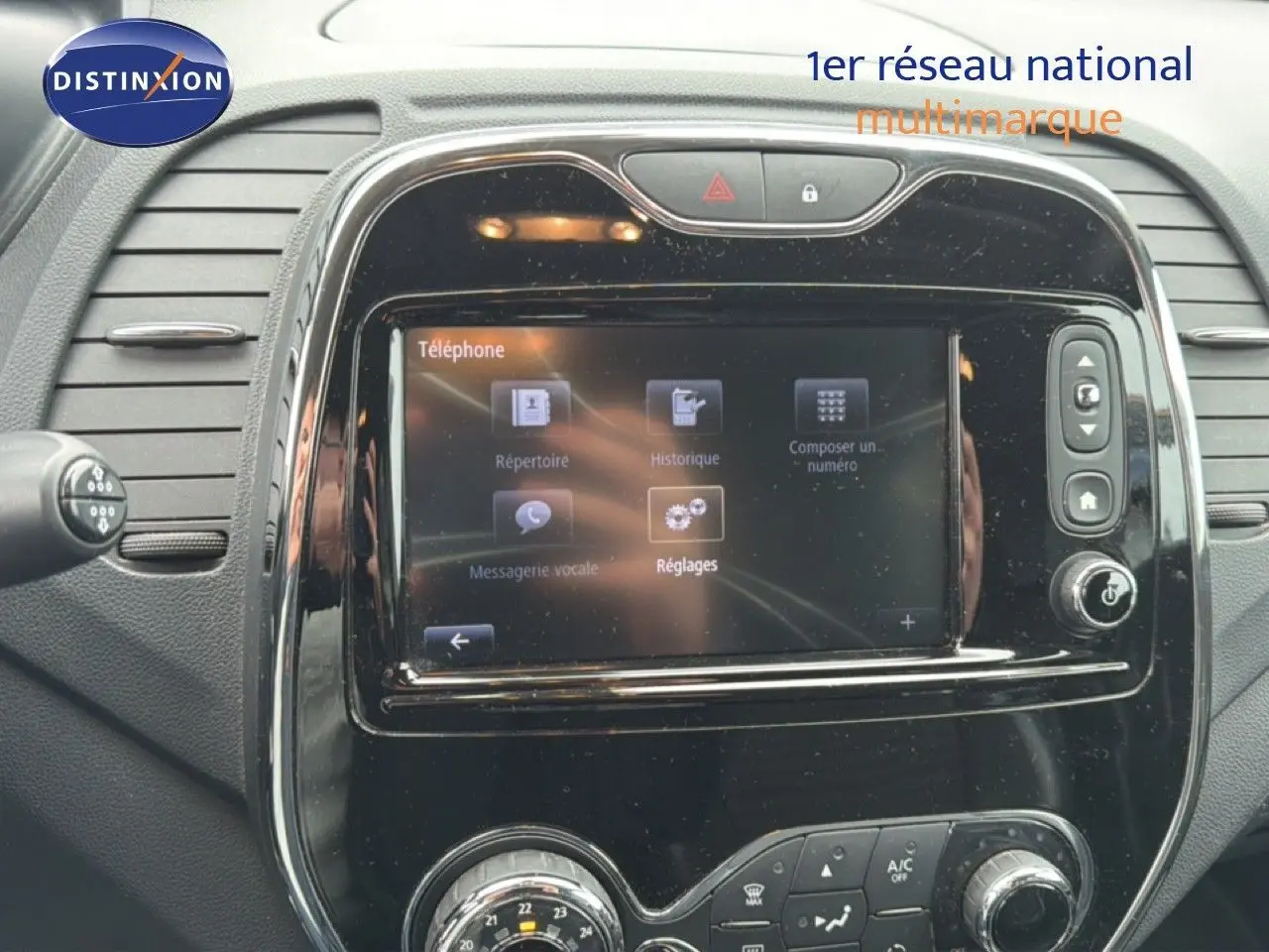 Tableau de bord de Renault Captur 2016 avec écran tactile et commandes de climatisation en vue frontale rapprochée.