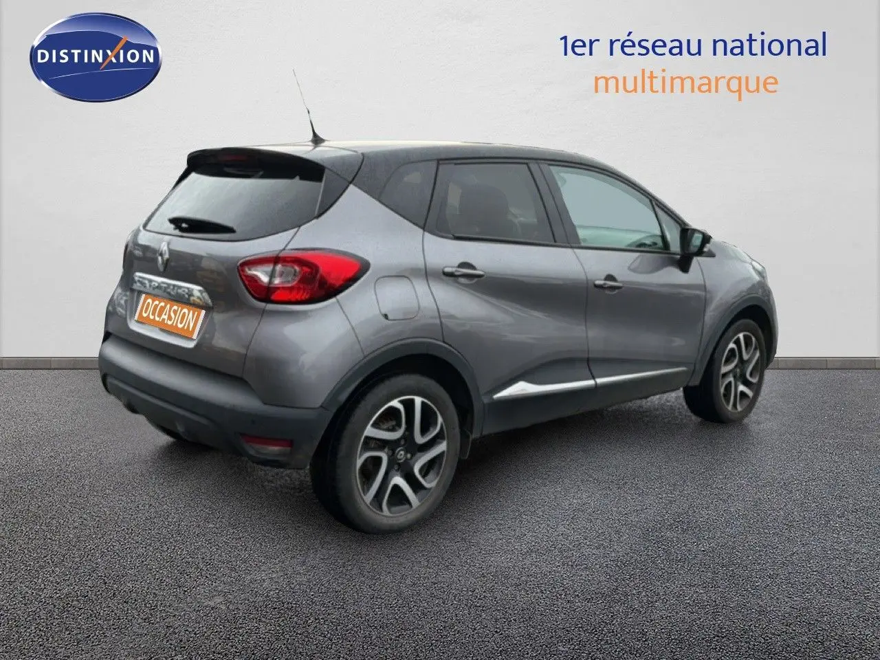 Vue 3/4 arrière droite d'un Renault Captur gris Cassiopée avec toit noir et jantes alliage bicolores.