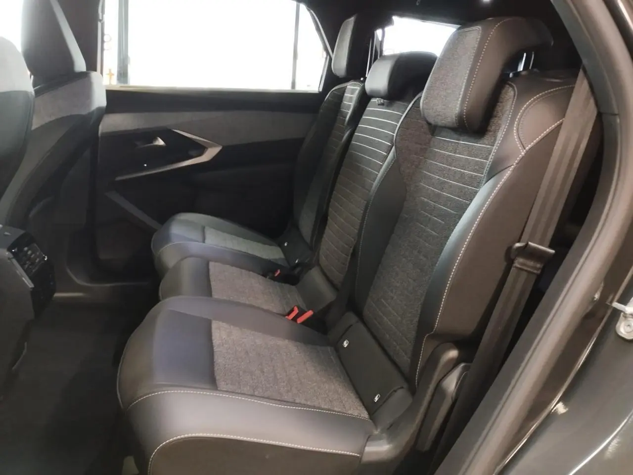 Vue latérale droite des sièges arrière gris tissu et cuir du Peugeot 5008 2025 finition Allure hybride.