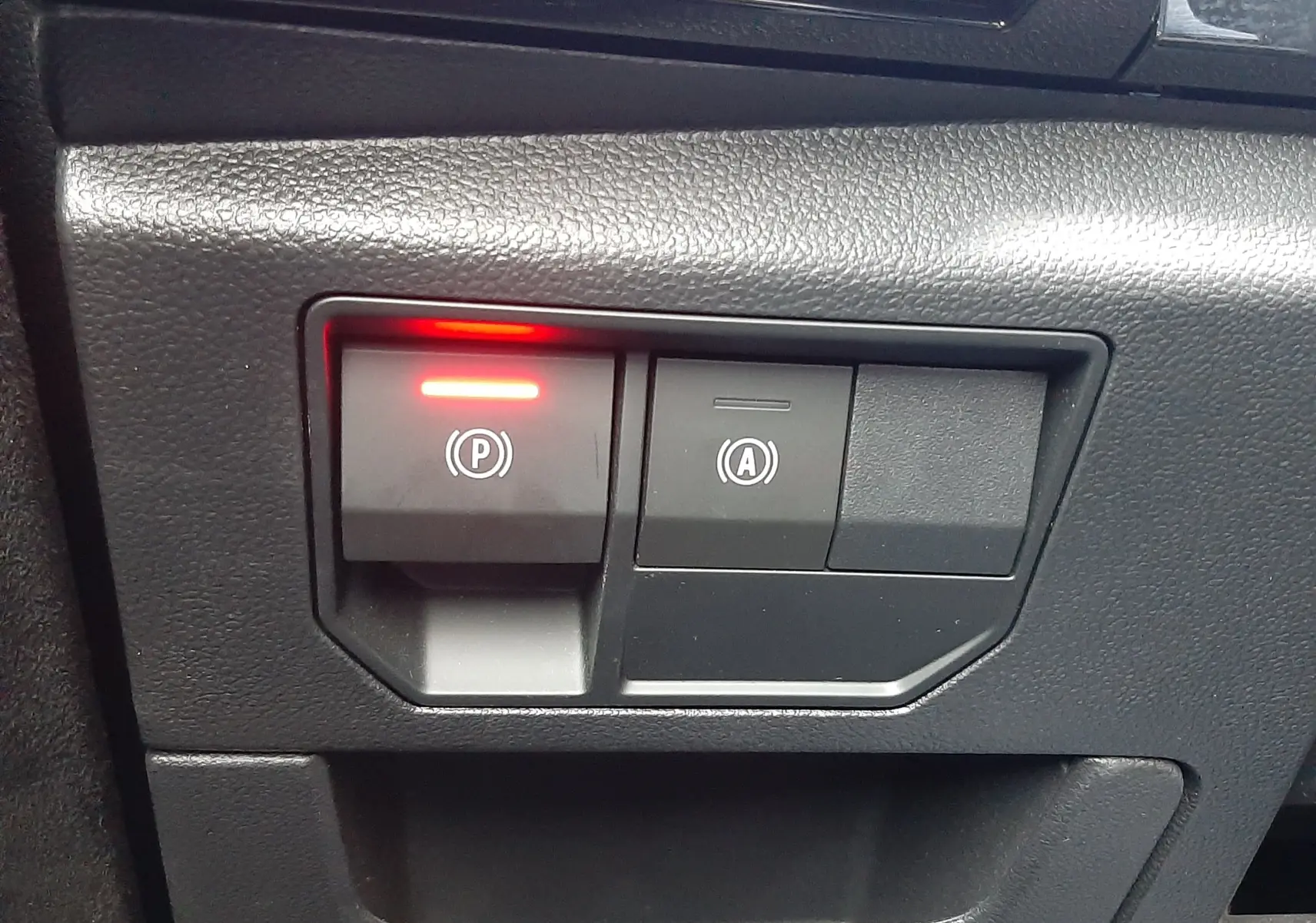 Gros plan sur les commandes de frein à main électronique et arrêt automatique du moteur du Renault Austral 2025, intérieur noir.