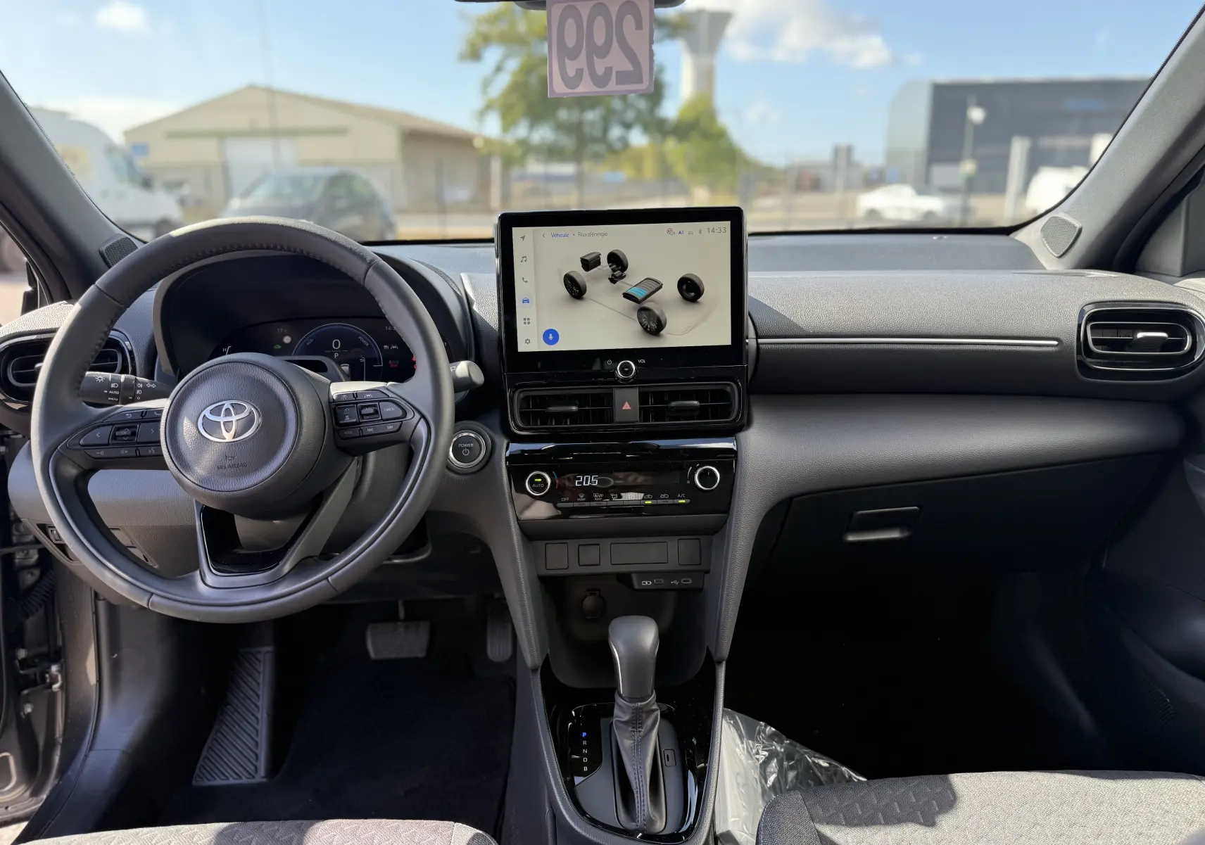 Vue intérieure avant de la Toyota Yaris Cross 2026 gris atlas, avec tableau de bord moderne et écran tactile central.