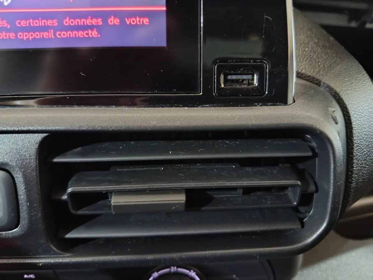 Détail de la prise USB et de la sortie d'air noire sur le tableau de bord du Citroën Berlingo blanc de 2021.