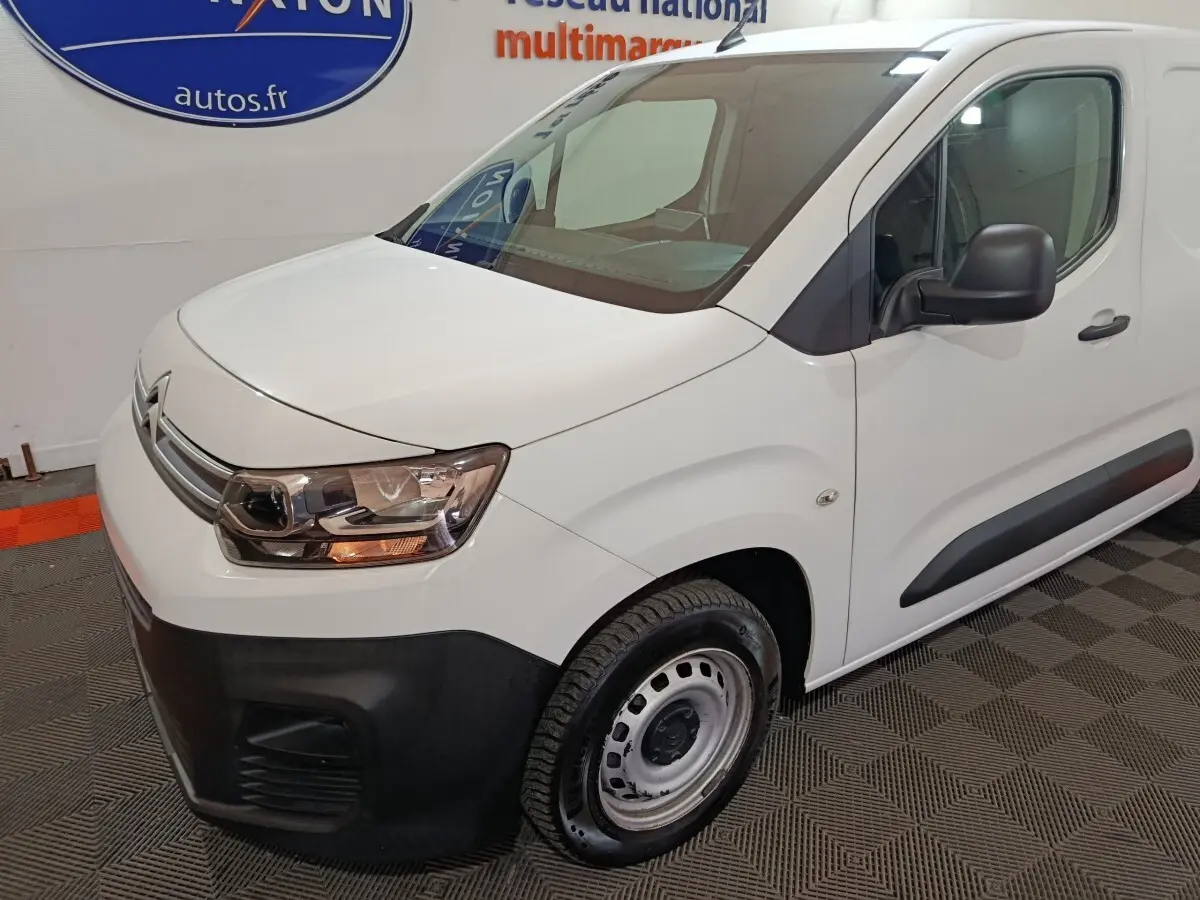 Vue 3/4 avant droit d'un utilitaire Citroën Berlingo blanc avec pare-chocs noir et jantes acier.
