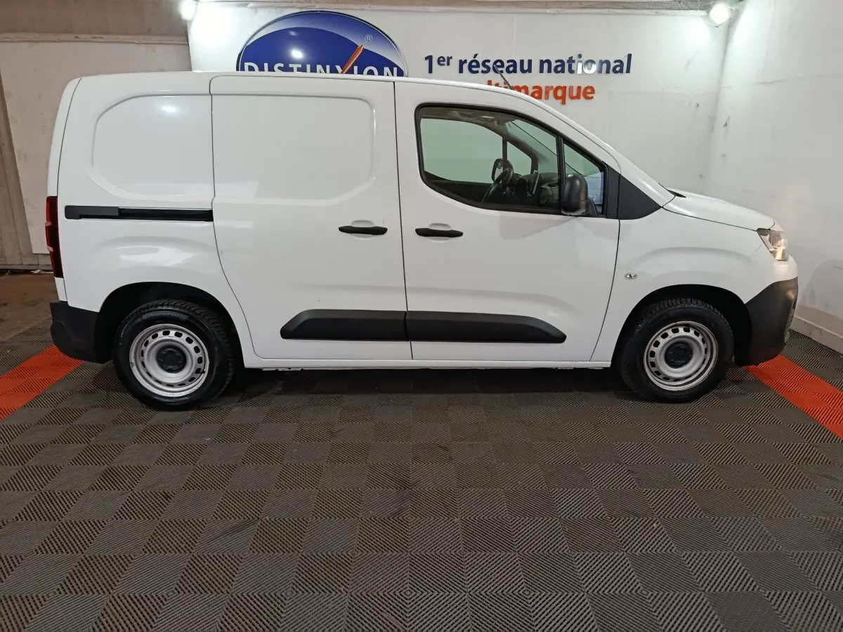 Vue de profil côté droit d’un utilitaire Citroën Berlingo blanc avec jantes acier et portes latérales pleines.