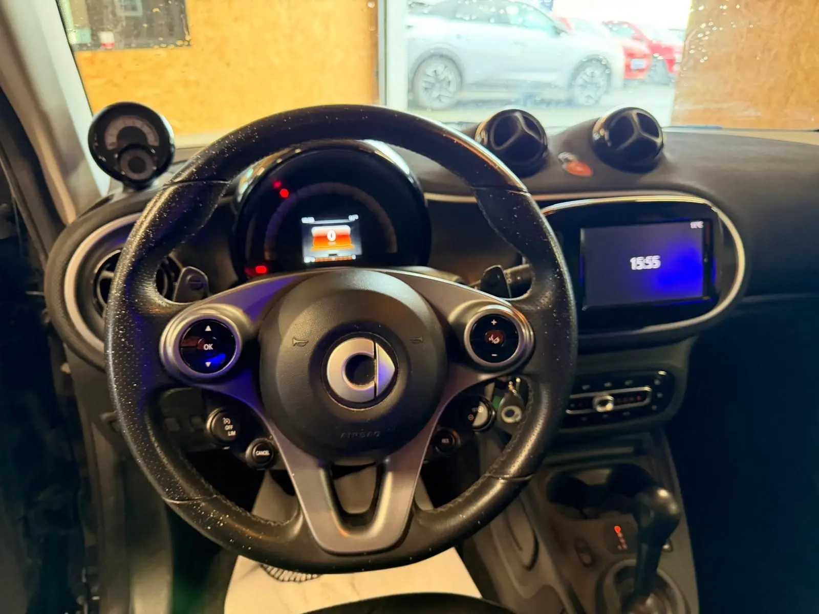 Vue intérieure centrée sur le volant multifonctions de la Smart Fortwo Cabrio 2019 avec tableau de bord et écran tactile.