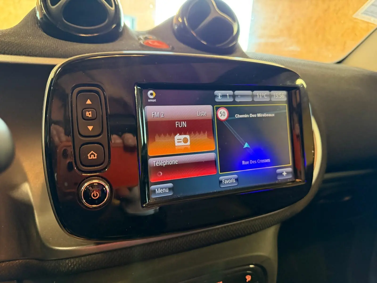 Vue rapprochée de l’écran tactile GPS du tableau de bord de la Smart Fortwo Cabrio noir, affichant la navigation.
